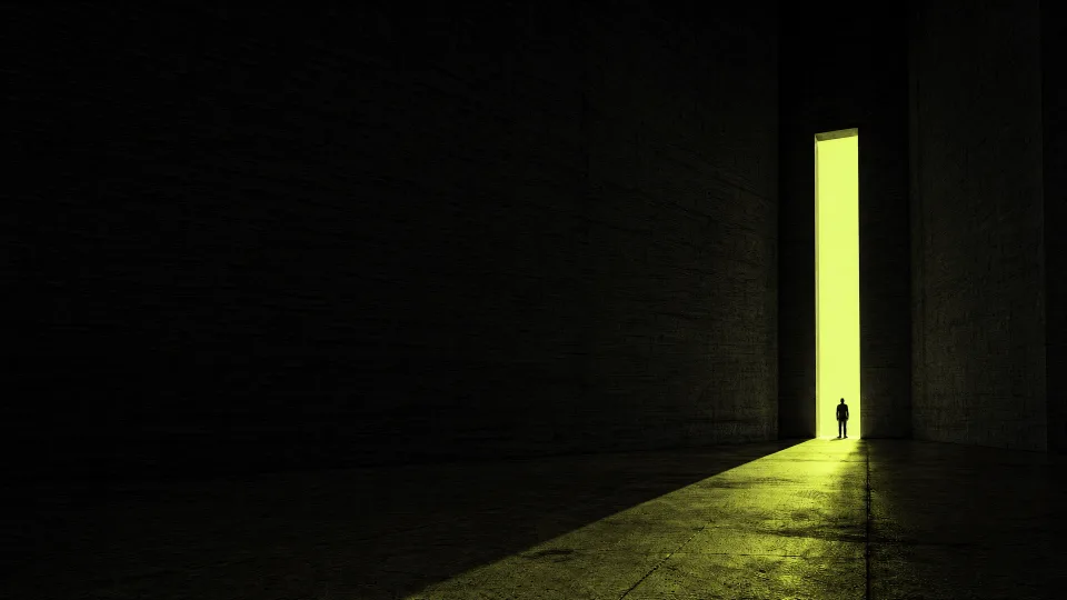 Een ruimte van beton met een hoge smalle deuropening. Limoengroen licht valt binnen. Een klein silhouet staat op de drempel.
